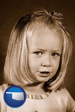 a sepia portrait of a female child - with Oklahoma icon
